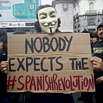 Anonymous sosteniendo un cartel que dice "Nobody expects the #SpanishRevolution" en la plaza del Sol de Madrid, España.